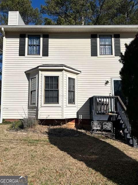 rear view of house featuring a lawn