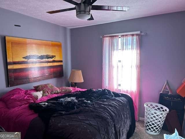 bedroom featuring ceiling fan, carpet, and a textured ceiling