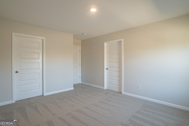 unfurnished bedroom featuring light carpet