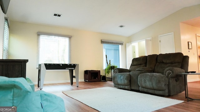 living room with light hardwood / wood-style floors and vaulted ceiling