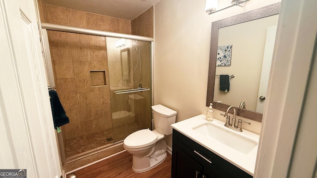 bathroom featuring vanity, toilet, an enclosed shower, and hardwood / wood-style floors