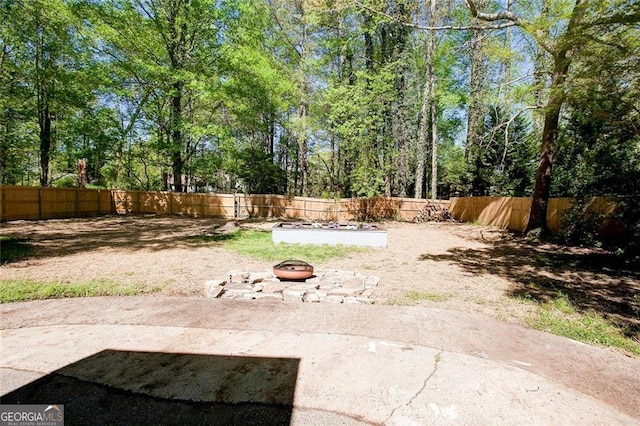 view of yard featuring a patio and an outdoor fire pit