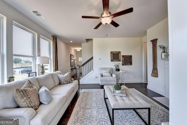 living room with dark wood-type flooring and ceiling fan