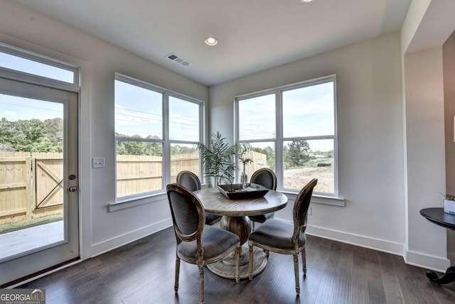 dining room with a wealth of natural light and dark wood-type flooring