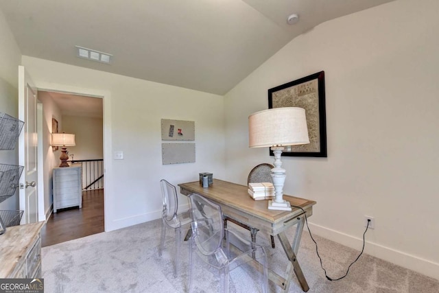 carpeted office space with vaulted ceiling