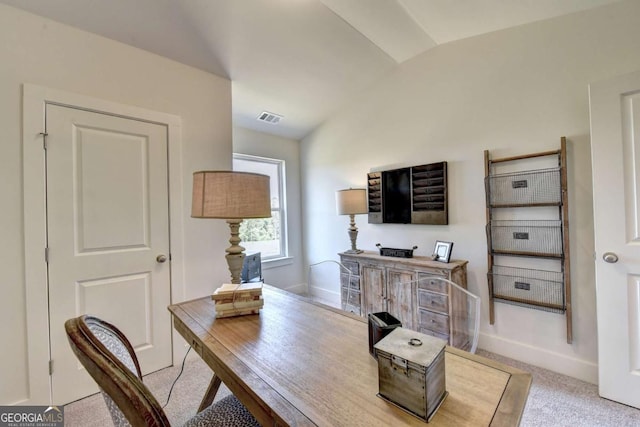 carpeted office with lofted ceiling