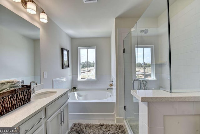 bathroom featuring vanity and shower with separate bathtub