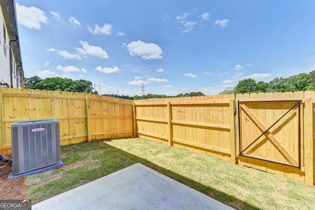 view of yard with central AC unit and a patio area