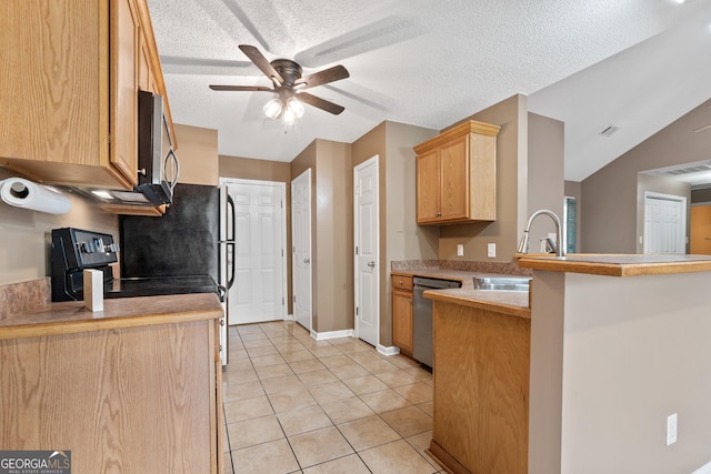 kitchen featuring light brown cabinetry, a textured ceiling, light tile patterned floors, kitchen peninsula, and stainless steel appliances