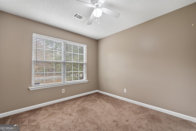 carpeted spare room featuring ceiling fan and a textured ceiling