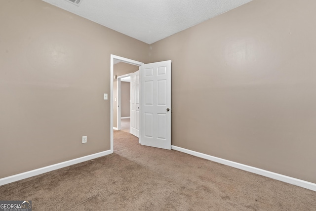 carpeted empty room with a textured ceiling