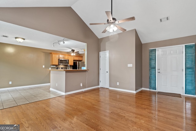 unfurnished living room with high vaulted ceiling, light hardwood / wood-style floors, and ceiling fan