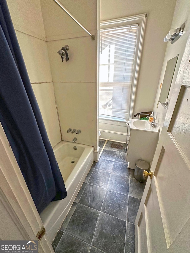 bathroom with shower / tub combo with curtain, vanity, and a healthy amount of sunlight