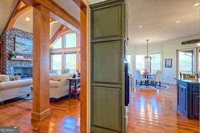 kitchen with a stone fireplace, light hardwood / wood-style flooring, green cabinets, a notable chandelier, and pendant lighting