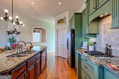 kitchen featuring sink, hardwood / wood-style flooring, stainless steel appliances, tasteful backsplash, and decorative light fixtures