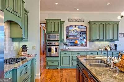 kitchen with sink, decorative backsplash, ornamental molding, and stainless steel appliances