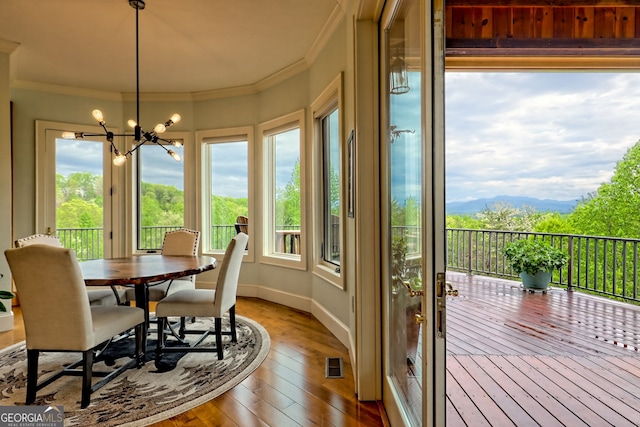 4431 Furman Gribble Rd, Young Harris, GA 30582 - sunroom featuring wood-type flooring, ornamental molding, a chandelier, baseboards, and a mountain view