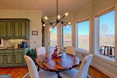 dining area with crown molding, hardwood / wood-style floors, and an inviting chandelier