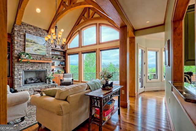 4431 Furman Gribble Rd, Young Harris, GA 30582 - living room featuring wood-type flooring, a stone fireplace, a chandelier, high vaulted ceiling, and baseboards