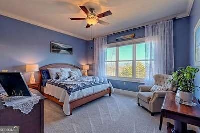 bedroom featuring crown molding, light colored carpet, and ceiling fan