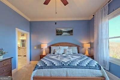 carpeted bedroom featuring crown molding and ceiling fan