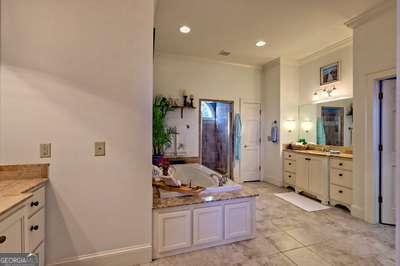 bathroom with vanity, crown molding, and a bathtub