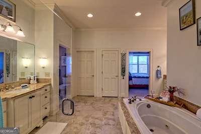 bathroom with vanity, a relaxing tiled tub, and crown molding