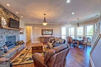 living room with wood-type flooring, crown molding, and a fireplace