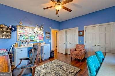 home office with ceiling fan and dark hardwood / wood-style flooring