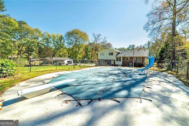 view of pool with a fenced in pool, a patio, a water slide, and fence