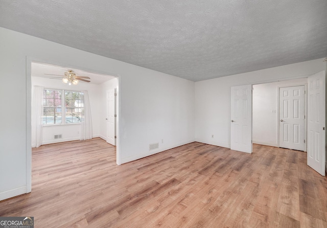 interior space featuring visible vents, a textured ceiling, and light wood-style floors