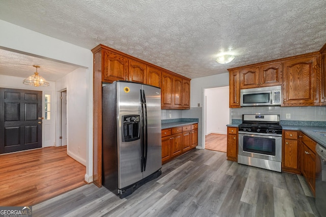 kitchen featuring dark wood-style floors, brown cabinets, and appliances with stainless steel finishes