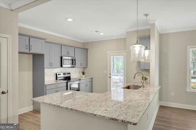 kitchen with crown molding, decorative light fixtures, dark hardwood / wood-style flooring, a barn door, and light stone countertops