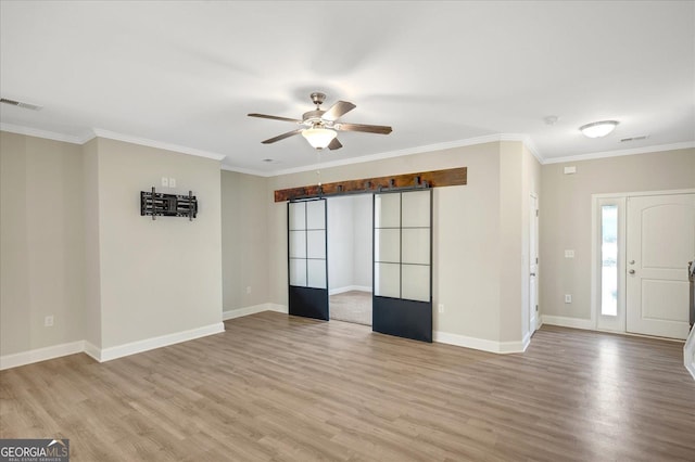 interior space featuring crown molding, ceiling fan, and light hardwood / wood-style floors