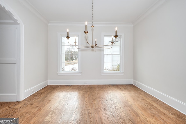 unfurnished dining area with crown molding, light hardwood / wood-style flooring, and a chandelier