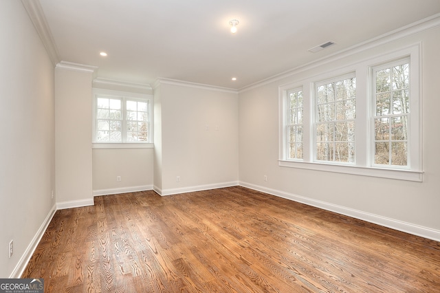 spare room with ornamental molding and hardwood / wood-style floors