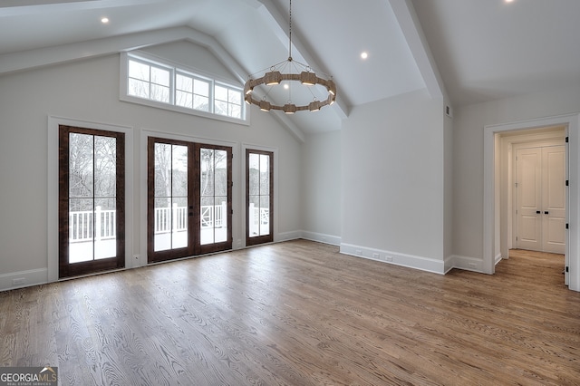 interior space featuring french doors, a notable chandelier, high vaulted ceiling, and hardwood / wood-style flooring