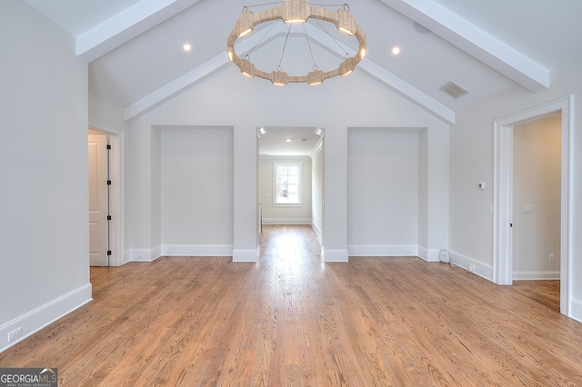 unfurnished room with lofted ceiling with beams, a notable chandelier, and light hardwood / wood-style flooring