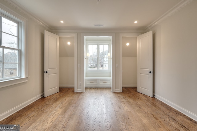 unfurnished bedroom featuring multiple windows, ornamental molding, and light hardwood / wood-style floors