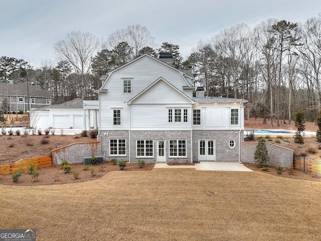 rear view of house featuring a patio, a yard, central AC unit, a fenced in pool, and french doors