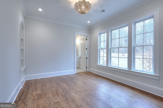 unfurnished room with ornamental molding and wood-type flooring