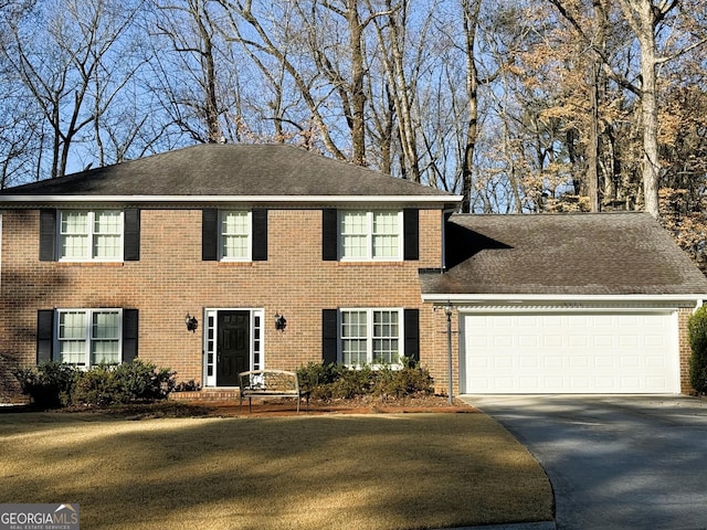 colonial house with a garage and a front yard