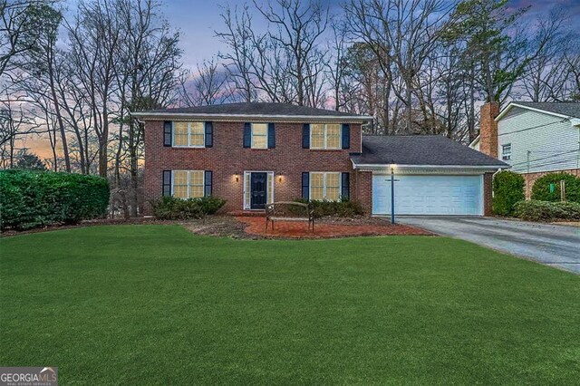 colonial home with a garage and a front yard