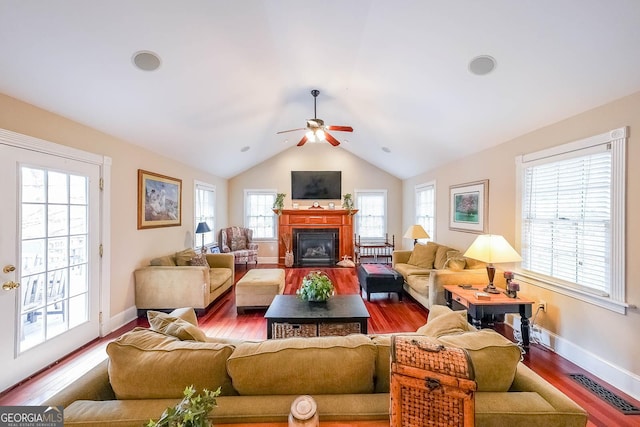 living room featuring a fireplace with flush hearth, wood finished floors, visible vents, and lofted ceiling