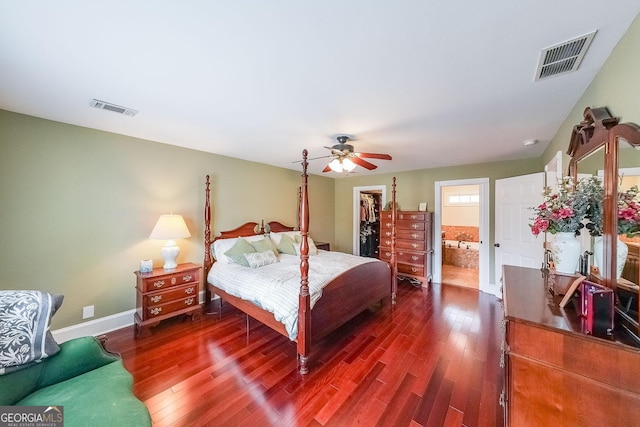 bedroom featuring dark wood-style floors, a closet, a walk in closet, and visible vents