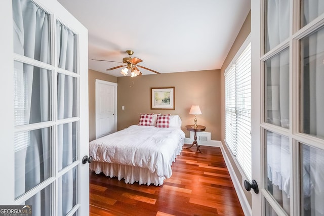 bedroom featuring french doors, visible vents, a ceiling fan, wood finished floors, and baseboards