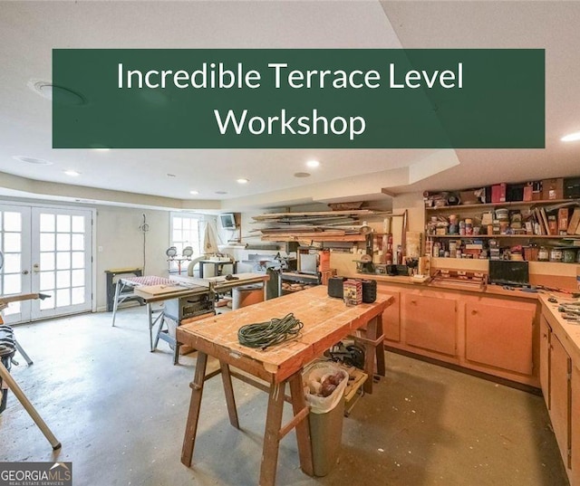 interior space with concrete floors, a workshop area, and french doors