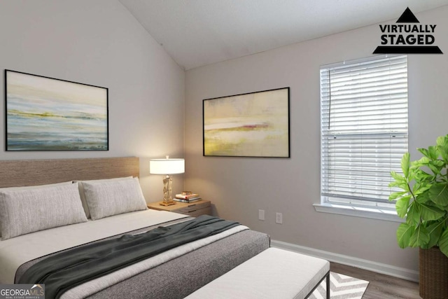 bedroom featuring vaulted ceiling and hardwood / wood-style floors