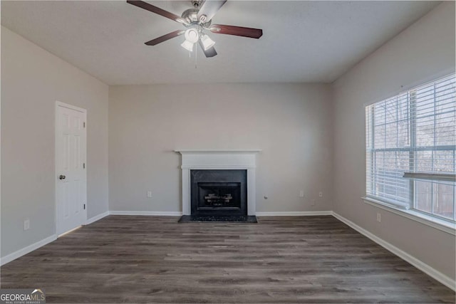 unfurnished living room featuring dark wood-type flooring and ceiling fan