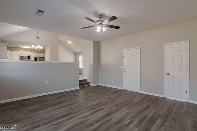 unfurnished living room featuring lofted ceiling, dark hardwood / wood-style floors, ceiling fan with notable chandelier, and a textured ceiling